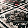 rummy A close-up view of a neatly arranged set of playing cards spread out on a smooth, dark surface. The cards are fanned out in a way that showcases their